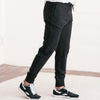 Batch Men's Essential Joggers – Black Cotton French Terry Image Standing on Body Side with Sneakers